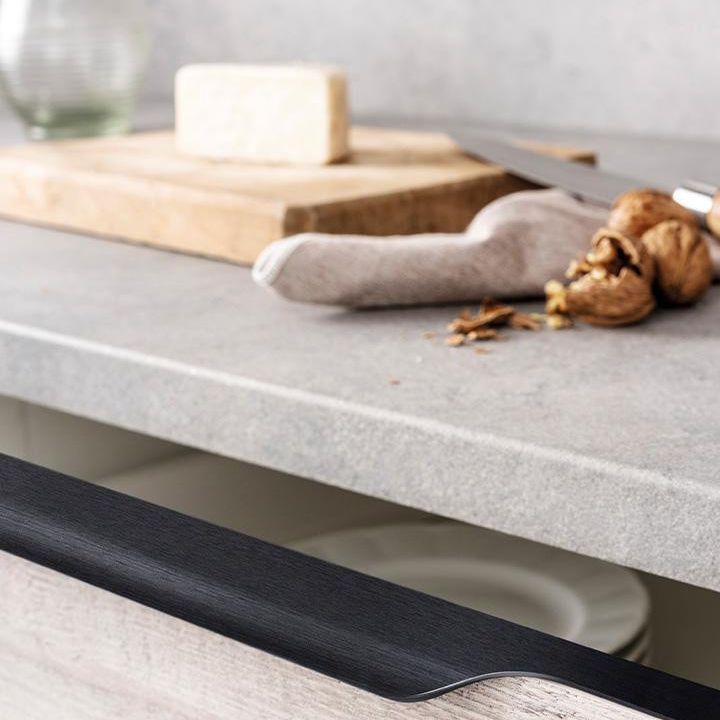 VECTOR Aluminium-Profilgriff mit ergonomischem, abgerundetem Design an einer modernen Küchenschranktür montiert.