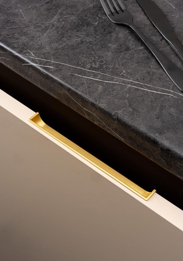 HIDE Einlassgriff aus Zamak mit minimalistischem integriertem Design an einer modernen Schubladenfront montiert.
